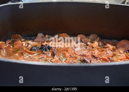 Cocotte de bœuf dans une bière avec carottes et anis dans une poêle à frire Banque D'Images