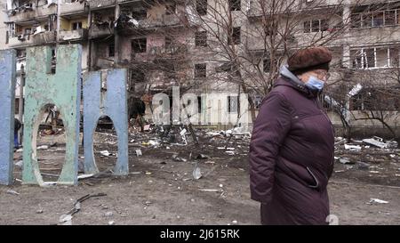 KIEV, UKRAINE 25 FÉVRIER. Un civil passe devant un immeuble résidentiel endommagé à la suite d'une attaque à la roquette le 25 février 2022 à Kiev, en Ukraine. La Russie a commencé une invasion militaire de l'Ukraine après que le Parlement russe ait approuvé des traités avec deux régions sécessionnistes de l'est de l'Ukraine. C'est le plus grand conflit militaire en Europe depuis la Seconde Guerre mondiale Banque D'Images