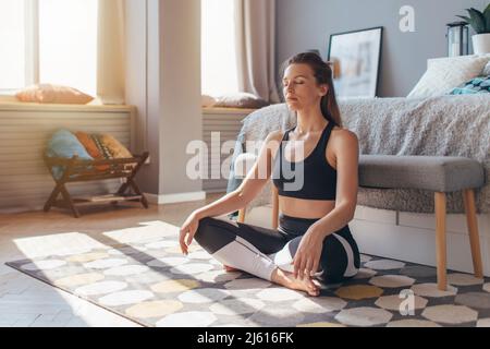 Femme assise sur le sol à la maison et relaxante Banque D'Images