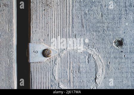 Une ancienne surface en bois gris avec une étiquette en aluminium clouée dessus. Le numéro neuf est gravé sur l'étiquette. Planches sales rugueuses. La texture du bois. ABS Banque D'Images