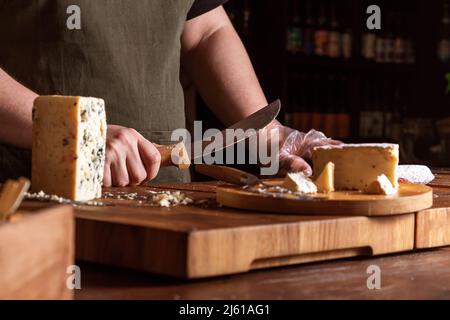 Vendeur, couteau au comptoir du magasin de fromage. Banque D'Images