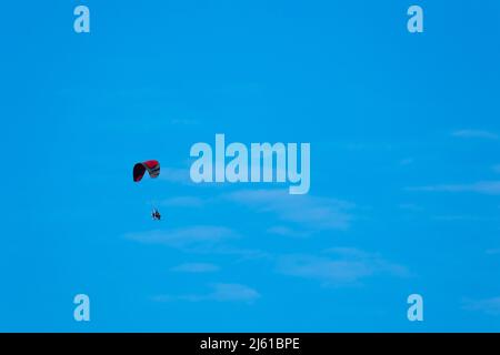 Des parapentes à motifs volent sur le fond d'un ciel bleu. Photo prise par beau temps, en fin d'après-midi Banque D'Images