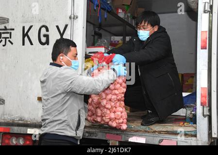 Pékin, Chine. 27th avril 2022. Les membres du personnel déchargent les légumes d'un camion dans une zone résidentielle du district de Haidian, Beijing, capitale de la Chine, le 27 avril 2022. Les collectivités du district de Haidian ont renforcé l'offre de produits de première nécessité quotidiens pour les résidents à la suite d'une récente résurgence de la COVID-19. Crédit: REN Chao/Xinhua/Alay Live News Banque D'Images