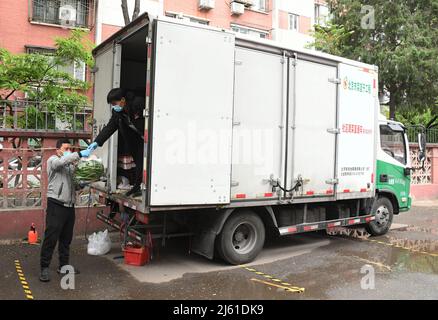 Pékin, Chine. 27th avril 2022. Les membres du personnel déchargent les légumes d'un camion dans une zone résidentielle du district de Haidian, Beijing, capitale de la Chine, le 27 avril 2022. Les collectivités du district de Haidian ont renforcé l'offre de produits de première nécessité quotidiens pour les résidents à la suite d'une récente résurgence de la COVID-19. Crédit: REN Chao/Xinhua/Alay Live News Banque D'Images