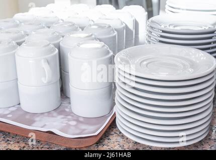 Un buffet de plats blancs et de tasses est disponible sur la table. Banque D'Images