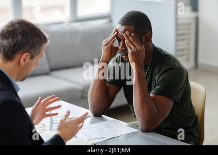 Psychiatre professionnel ayant une séance de thérapie avec un jeune militaire afro-américain avec PTSD Banque D'Images