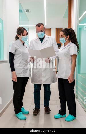 Médecin avec des infirmières discutant du rapport médical dans la clinique maxillofaciale Banque D'Images