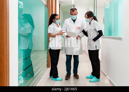 Médecin discutant du rapport médical avec les infirmières dans le couloir de l'hôpital Banque D'Images