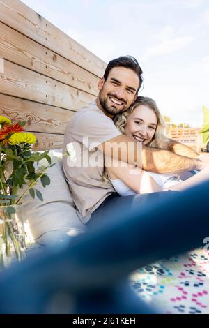Un homme heureux avec une petite amie qui profite de la terrasse Banque D'Images