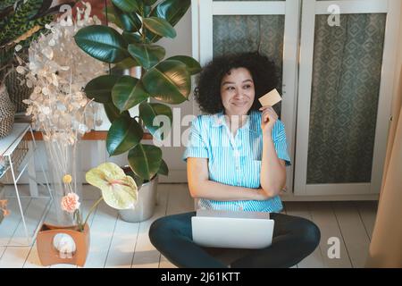 Femme attentionnés avec carte de crédit et ordinateur portable faisant des achats en ligne à la maison Banque D'Images
