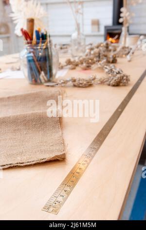 Table de travail en bois avec règle en laiton avec brûleur en bois hors foyer au loin. Banque D'Images