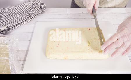 Étape par étape. Coupe de fudge de canne à sucre fait maison sur un tableau de découpe blanc. Banque D'Images