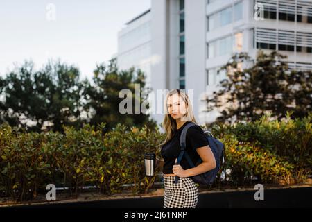 Femme d'affaires avec tasse de café isolée par les plantes Banque D'Images