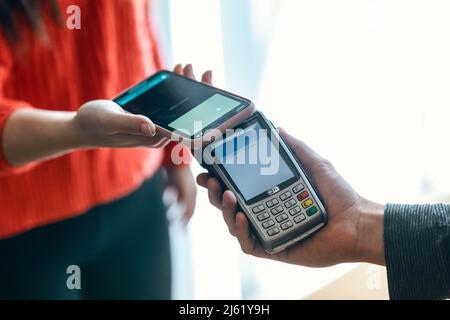 Main de la femme effectuant le paiement sans contact par téléphone mobile Banque D'Images
