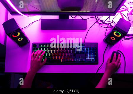 Garçon avec clavier d'ordinateur et souris jouant au jeu sur ordinateur Banque D'Images