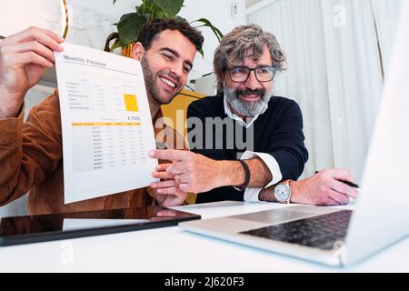 Des journalistes indépendants souriants expliquent le document sur appel vidéo via un ordinateur portable à la maison Banque D'Images