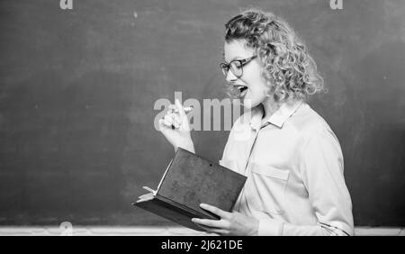 Femme enseignante devant le tableau de surveillance.Passionné par la connaissance.Pédalo tenir le livre et expliquer l'information.Concept d'éducation.Enseignant Banque D'Images