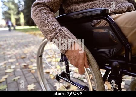 Homme senior handicapé assis en fauteuil roulant au parc Banque D'Images