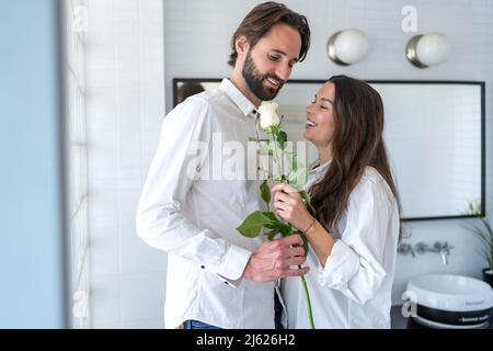 Couple tenant une rose blanche à la maison Banque D'Images