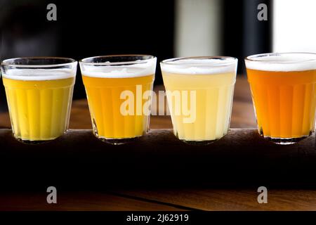 quatre verres de différents types de bière, bière à la pression, bière de blé et autres types mis en place pour la dégustation Banque D'Images