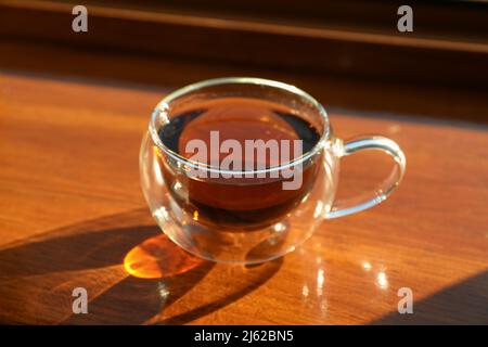 Une tasse de thé se trouve sur un rebord de fenêtre en bois Banque D'Images