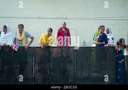 Les gens sortent de leur maison pour apercevoir le Premier ministre Boris Johnson lors de sa visite à Ahmedabad, dans le Gujarat, en Inde. Beaucoup, armés de drapeaux ont été encouragés à se tourner vers les autorités locales et des photos du Premier Ministre ornent chaque coin de rue. Ces photos ont été prises à partir d'un véhicule dans le convoi du PM car il a fait le chemin à ses différents engagements. Date de la photo : jeudi 21 avril 2022. Le crédit photo devrait se lire comme suit : Stefan Rousseau/PA Wire Banque D'Images