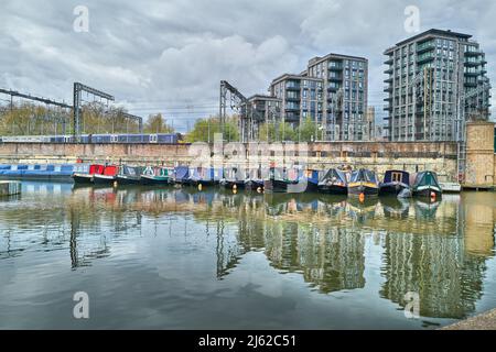 Des bateaux-canaux amarrés au bassin de St Pancras du canal Regent à côté de la ligne de chemin de fer de la gare de St Pancras, Londres, Angleterre. Banque D'Images