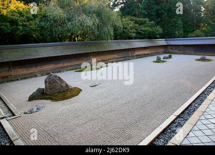 La vue de groupes séparés de rochers entourés par les vagues de gravier blanc dans le célèbre jardin zen en pierre du temple de Ryoan-ji. Kyoto. Japon Banque D'Images