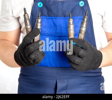 Le mécanicien de voiture tient les injecteurs de voiture de carburant dans sa main. Le concept de remplacement et de réglage du système de carburant d'une voiture à un service de voiture. Gros plan Banque D'Images