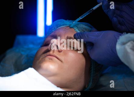 Médecin cosmétologue fait des injections de beauté pour lisser les rides du front. Traitement de l'ozone Banque D'Images