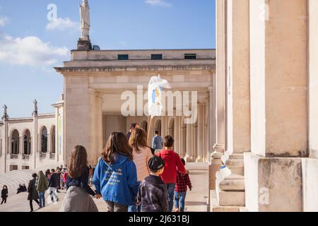 Pèlerins avec un drapeau de Sainte Marie en face de la basilique notre-Dame du Rosaire à Fatima Portugal Banque D'Images