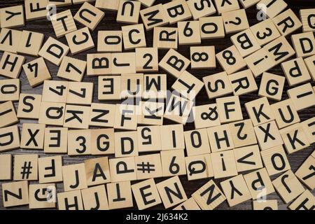 Carreaux en bois avec lettres et caractères latins sur une table (fond marron) Banque D'Images