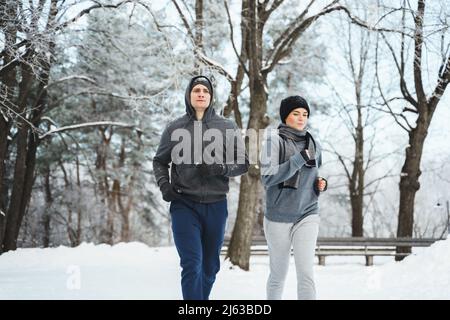 Couple sportif pendant le jogging d'hiver dans le parc de la ville Banque D'Images