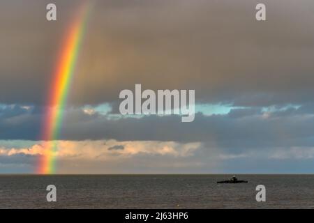 HERNE BAY : une douche à effet pluie sur la mer laisse place à un arc-en-ciel vibrant assis à côté de la vieille tête de pierhead juste avant le coucher du soleil. Banque D'Images