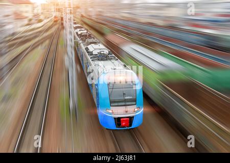 Train urbain avec phares sur les rushes le long des voies ferrées, vue aérienne supérieure Banque D'Images
