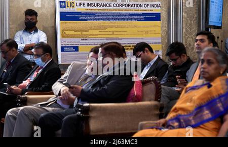 Mumbai, Inde. 27th avril 2022. Les gens sont vus près de l'affiche de la Société d'assurance vie de l'Inde (LIC) lors d'une conférence de presse à Mumbai. Leur offre publique initiale (IPO) sera ouverte au public le 4th mai 2022. (Photo par Ashish Vaishnav/SOPA Images/Sipa USA) crédit: SIPA USA/Alay Live News Banque D'Images