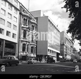 1960s, historique, voitures de l'époque en descendant Piccadilly, Londres, Angleterre, Royaume-Uni. Un bâtiment « moderne » construit dans les années d'après-guerre peut être vu dans l'image au coin de la rue Clarges. De forme rectangulaire et construits en béton précoulé avec panneaux de fenêtres construits hors site, ces bâtiments « modérés » étaient plus rapides et moins chers à construire que ceux traditionnellement construits en brique. Cependant, beaucoup étaient ternes, peu attrayantes et ne sont pas en harmonie avec les autres bâtiments et n'ont pas duré l'épreuve du temps. La salle d'exposition Jaguar du 88 Piccadilly est visible sur la gauche. Banque D'Images