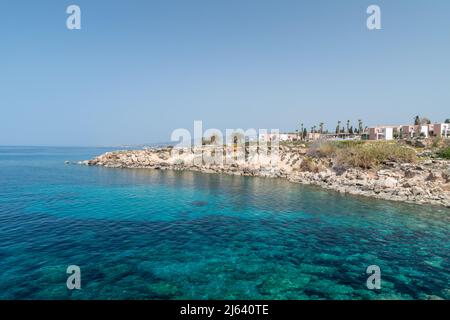 Côte rocheuse avec de belles eaux bleues claires sur la mer Méditerranée. Bord de mer sur le Chloraka, Chypre. Banque D'Images