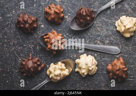 Truffes au chocolat. Pralines sucrées sur une table noire. Vue de dessus. Banque D'Images