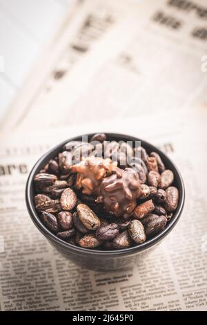 Fèves de cacao et truffes au chocolat dans un bol. Pralines douces. Banque D'Images