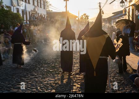 Les pénitents à capuchon catholiques romains portant des capirotes traditionnels tiennent une procession de silence le samedi Saint, 16 avril 2022 à Patzcuaro, Michoacan, Mexique. La petite ville indigène conserve les traditions de la domination coloniale espagnole, y compris la confraternité des pénitents pendant la semaine sainte. Banque D'Images