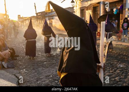 Les pénitents à capuchon catholiques romains portant des capirotes traditionnels tiennent une procession de silence le samedi Saint, 16 avril 2022 à Patzcuaro, Michoacan, Mexique. La petite ville indigène conserve les traditions de la domination coloniale espagnole, y compris la confraternité des pénitents pendant la semaine sainte. Banque D'Images