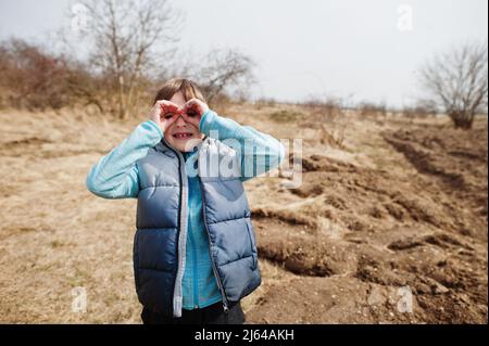 Garçon regarde à travers les mains jumelles. Banque D'Images