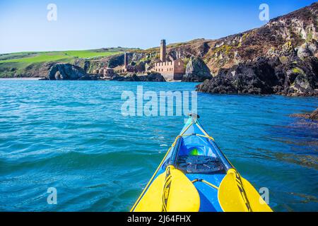 Kayak de mer au large de la côte d'Anglesey, au nord du pays de Galles. Approche de Porth Wen, site d'anciens travaux de brique Banque D'Images
