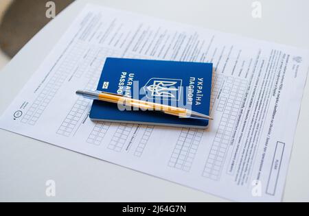 Document PESEL, passeport ukrainien et stylo sur fond de table blanc. Banque D'Images