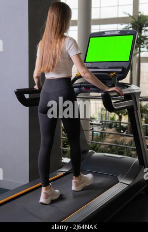 Longueur à l'intérieur jeune femme profil de tapis roulant femme pleine course, de l'entraînement de la forme dans le corps de l'entraînement sportif, muscles beaux. Soins pour l'homme, étroit, Banque D'Images