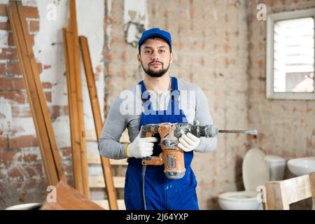 Constructeur confiant posant sur le chantier de construction intérieure Banque D'Images