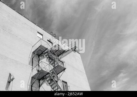LA NOUVELLE-ORLÉANS, LA, Etats-Unis - 19 AVRIL 2022 : image en noir et blanc d'une fuite au feu sur le côté d'un grand bâtiment et de nuages plus sages en arrière-plan Banque D'Images