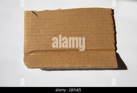 Un morceau de carton kraft déchiré sur fond blanc. Modèle, placer pour le texte. Banque D'Images