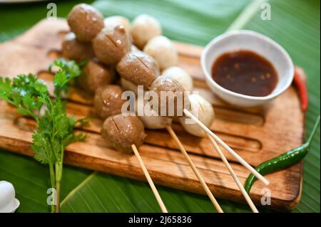 Gros plan, boulettes de viande grillées sur brochette avec sauce traditionnelle thaïlandaise spéciale et légumes. Banque D'Images